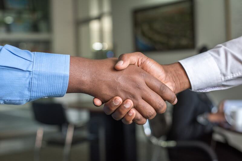 Two men who work at a startup, shaking hands 