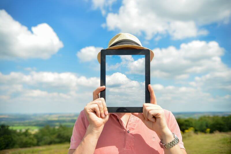 man-holding-up-a-tablet-see-through-clouds