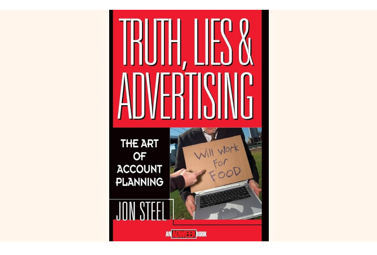 a man holding a cardboard sign that says truth lies and advertising