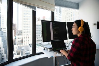 a woman wearing headphones is using a computer