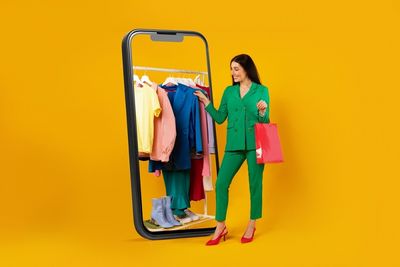 a woman standing next to a rack of clothes