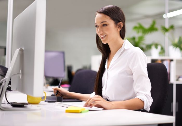 a woman sitting at a desk in front of a computer preview image