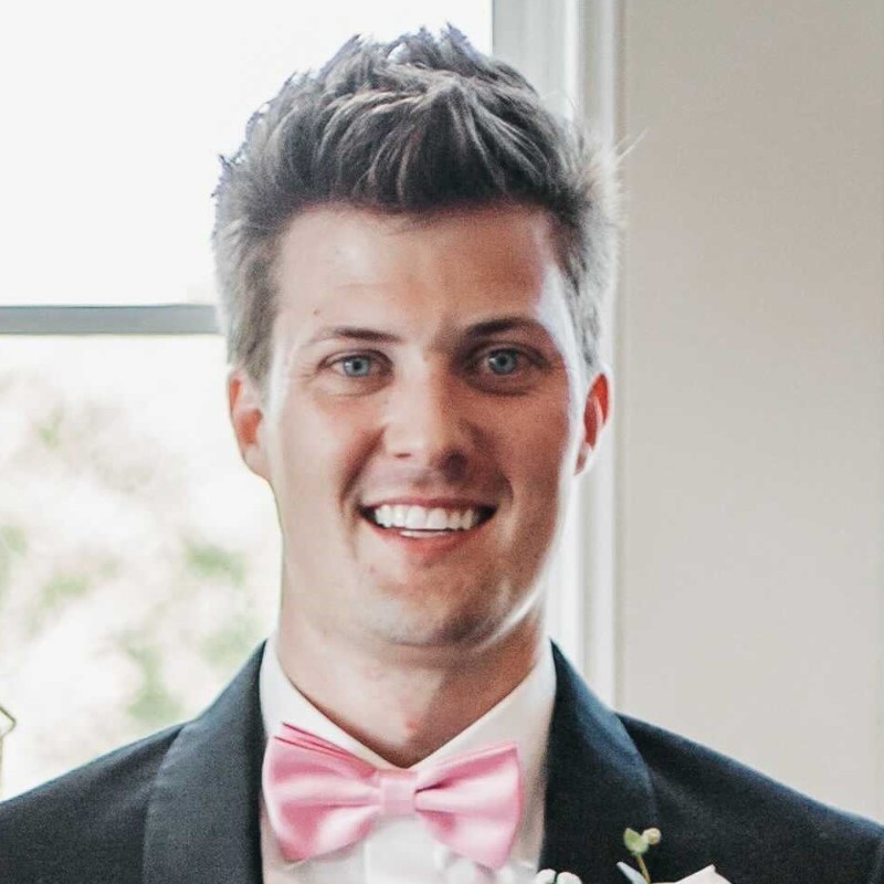 a man in a tuxedo smiles at the camera