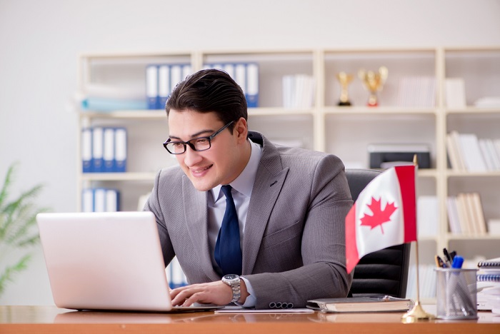 a man in a suit and tie working on a laptop in Canada